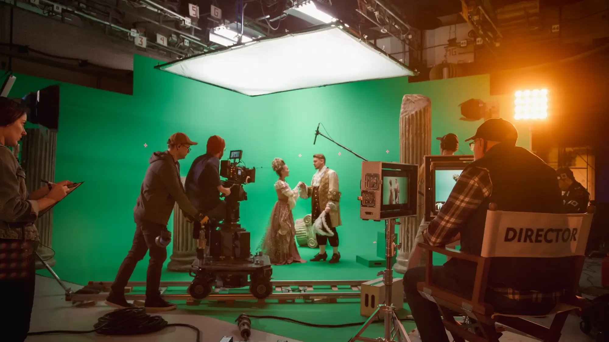 A film studio with professional lighting, cameras, and crew members working on a production set